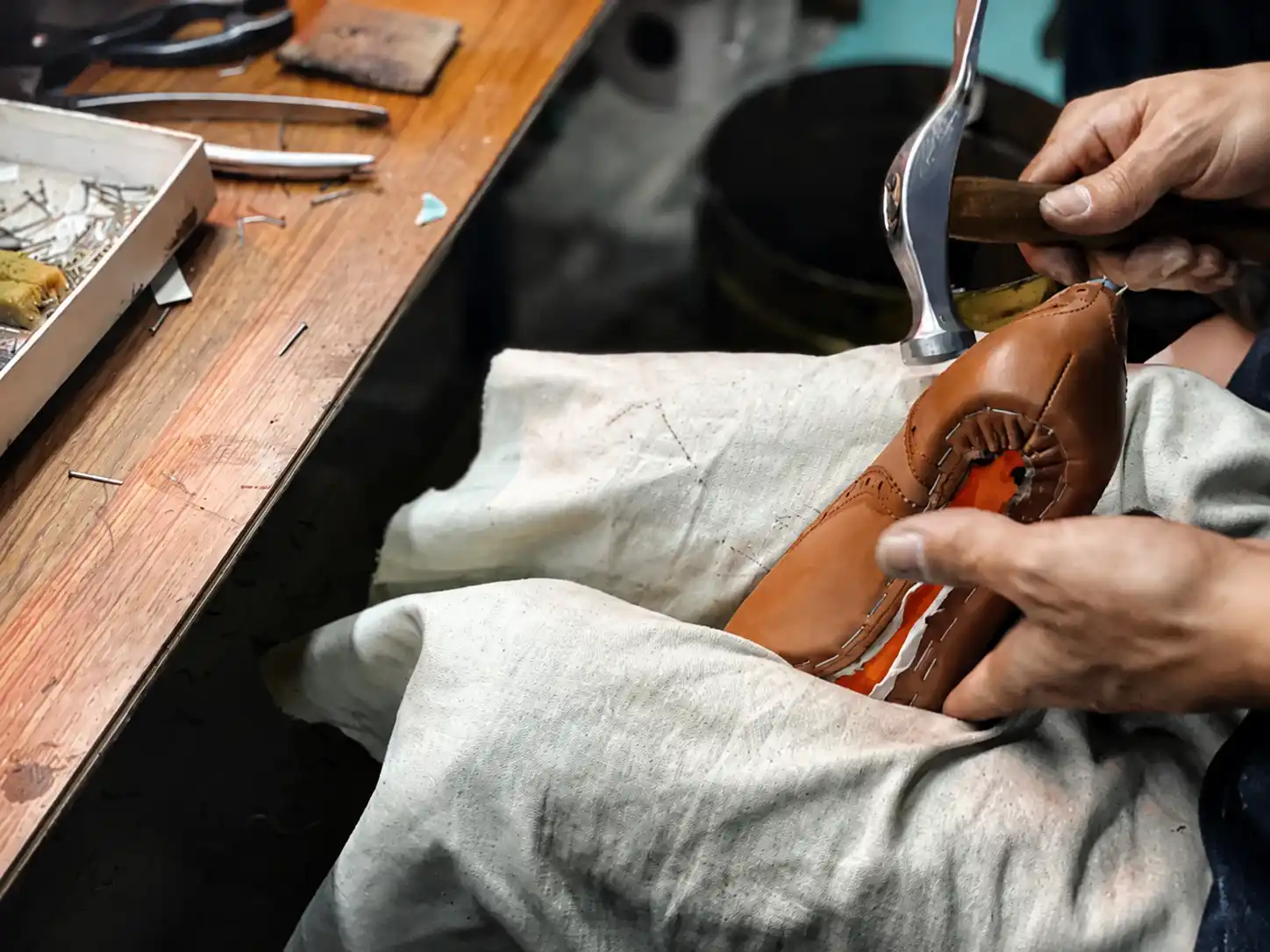 Craftsman Hand-Stitching a Brown Leather Sandal in Workshop